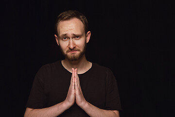 Image showing Close up portrait of young man isolated on black studio background