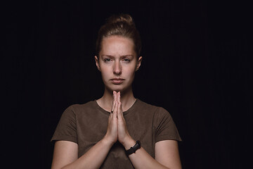 Image showing Close up portrait of young woman isolated on black studio background