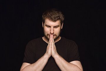 Image showing Close up portrait of young man isolated on black studio background