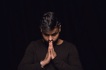 Image showing Close up portrait of young man isolated on black studio background