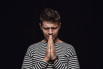 Image showing Close up portrait of young man isolated on black studio background