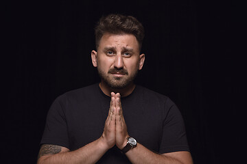 Image showing Close up portrait of young man isolated on black studio background