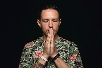 Image showing Close up portrait of young man isolated on black studio background