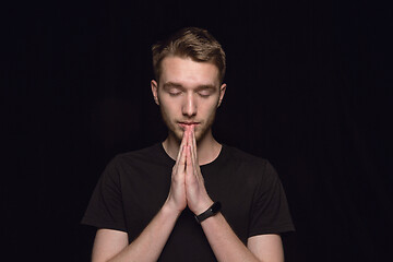 Image showing Close up portrait of young man isolated on black studio background