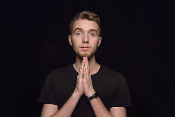 Image showing Close up portrait of young man isolated on black studio background