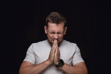 Image showing Close up portrait of young man isolated on black studio background