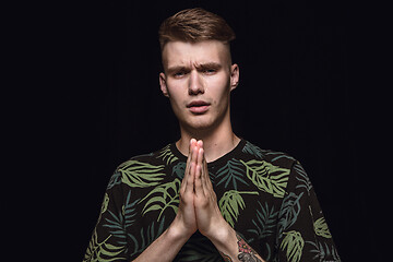 Image showing Close up portrait of young man isolated on black studio background