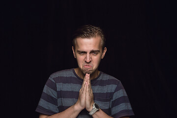 Image showing Close up portrait of young man isolated on black studio background