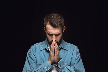 Image showing Close up portrait of young man isolated on black studio background