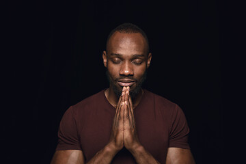 Image showing Close up portrait of young man isolated on black studio background