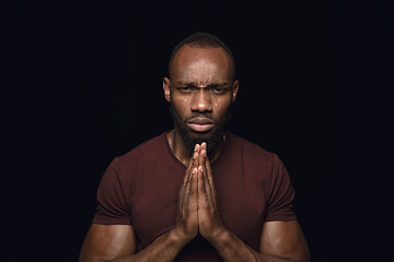 Image showing Close up portrait of young man isolated on black studio background