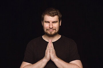 Image showing Close up portrait of young man isolated on black studio background