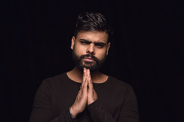 Image showing Close up portrait of young man isolated on black studio background