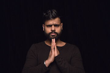 Image showing Close up portrait of young man isolated on black studio background