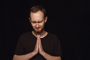 Image showing Close up portrait of young man isolated on black studio background