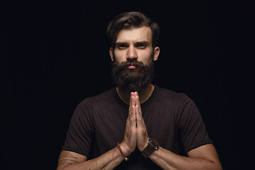 Image showing Close up portrait of young man isolated on black studio background