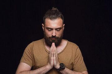 Image showing Close up portrait of young man isolated on black studio background