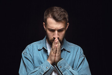 Image showing Close up portrait of young man isolated on black studio background