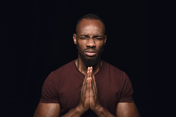 Image showing Close up portrait of young man isolated on black studio background