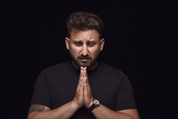 Image showing Close up portrait of young man isolated on black studio background