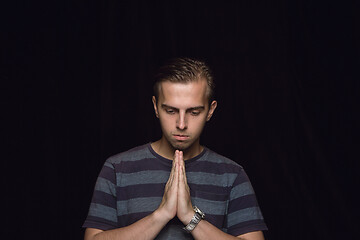 Image showing Close up portrait of young man isolated on black studio background