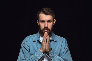 Image showing Close up portrait of young man isolated on black studio background