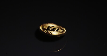 Image showing Shiny bitcoin spinning around on steel surface slow motion 120 fps