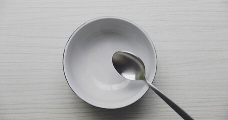 Image showing Clean bowl without food dropping spoon into it in slow motion from 120fps