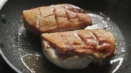 Image showing Roast duck breast in frying pen closeup footage