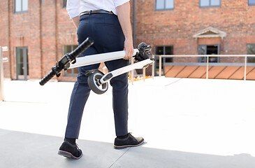 Image showing businessman with folding scooter on rooftop