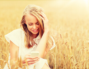 Image showing happy woman with smartphone and earphones