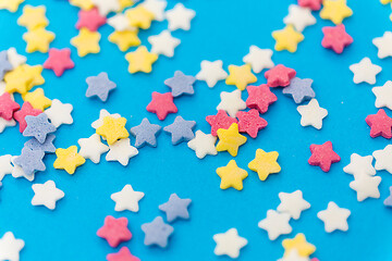 Image showing star shaped pastry sprinkles on blue background