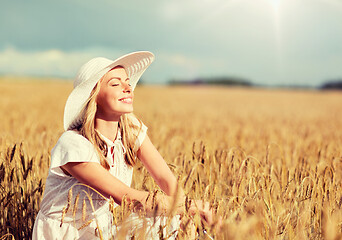 Image showing happy young woman in sun hat on cereal field