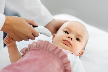 Image showing doctor with thermometer measures baby temperature