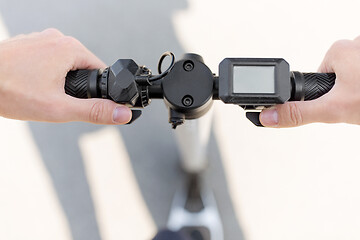 Image showing close up of hands holding electric scooter wheel