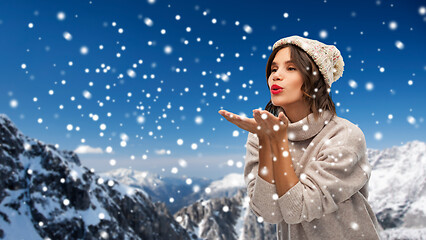 Image showing young woman in knitted winter hat sending air kiss