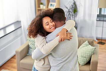 Image showing happy african american couple hugging at home