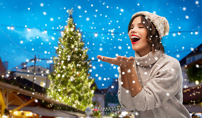 Image showing woman in hat sending air kiss at christmas market