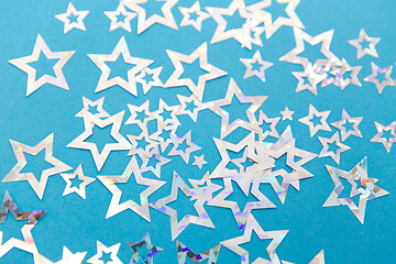 Image showing star shaped confetti decoration on blue background