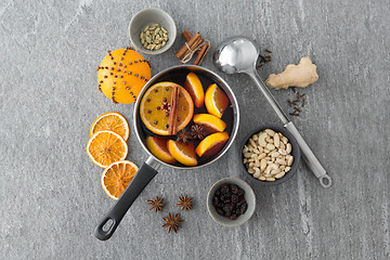 Image showing pot with hot mulled wine, orange slices and spices