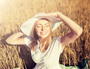 Image showing happy young woman in sun hat on cereal field