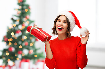 Image showing happy young woman in santa hat with red gift box