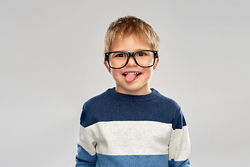 Image showing portrait of little boy in glasses showing tongue