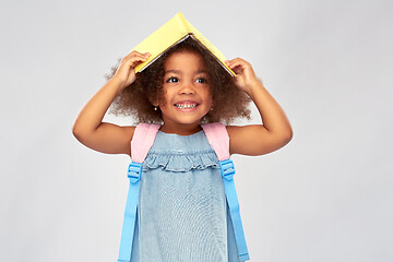 Image showing happy little african girl with book and backpack