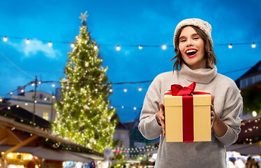 Image showing woman in hat holding gift box at christmas market