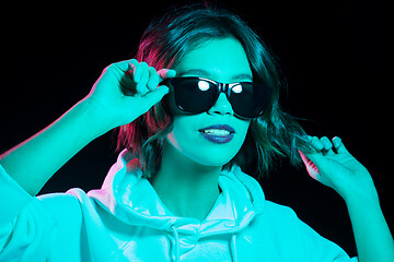 Image showing woman wearing hoodie in neon lights over black