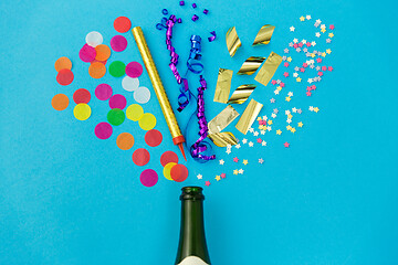 Image showing champagne bottle with birthday party props on blue