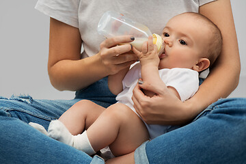 Image showing close up of mother feeding baby with milk formula