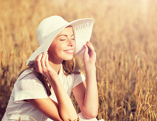 Image showing happy young woman in sun hat on cereal field