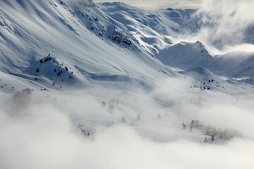 Image showing Mountain winter landscape with fog and clouds